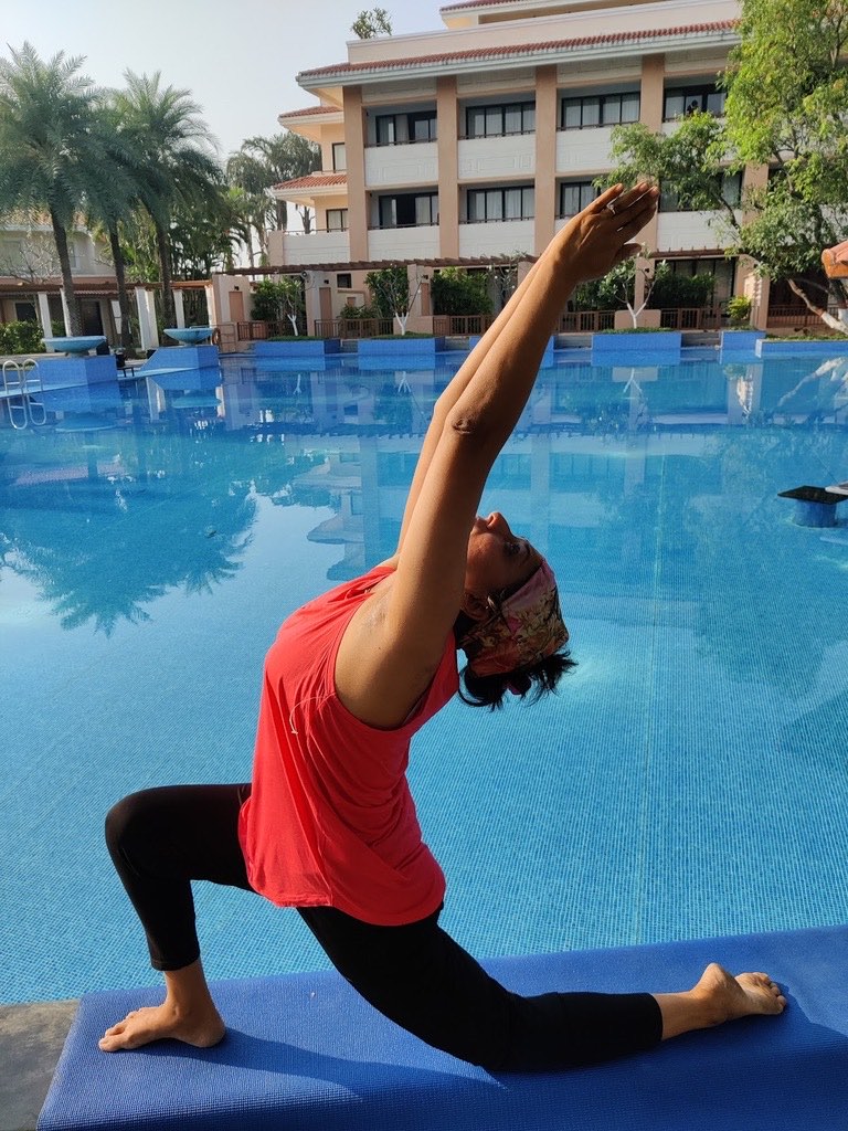 Sheetal Mody in a low lunge with her arms stretched overhead